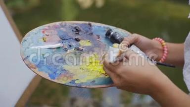 托盘上的女艺术家为4k的山水画铺上小颜料